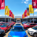 A modern car dealership with colorful banners and a diverse selection of new cars in various models and colors under a bright blue sky, creating an...