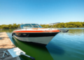 A gleaming boat docked by a tranquil lake, surrounded by lush greenery and clear blue skies, with maintenance tools subtly placed nearby, evoking a...