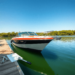 A gleaming boat docked by a tranquil lake, surrounded by lush greenery and clear blue skies, with maintenance tools subtly placed nearby, evoking a...