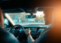 Modern car interior with glowing futuristic dashboard and abstract tech icons, driver using voice assistant hands-free, highlighting safety and sma...